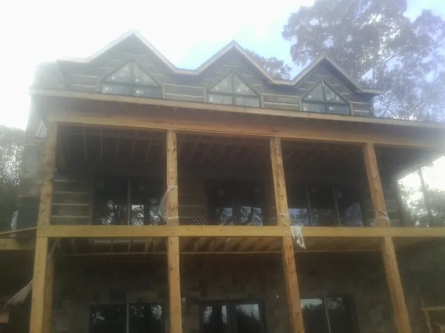 Dormers and porch framing on a large log home under construction — Roof Coating work by our crew in Codorus