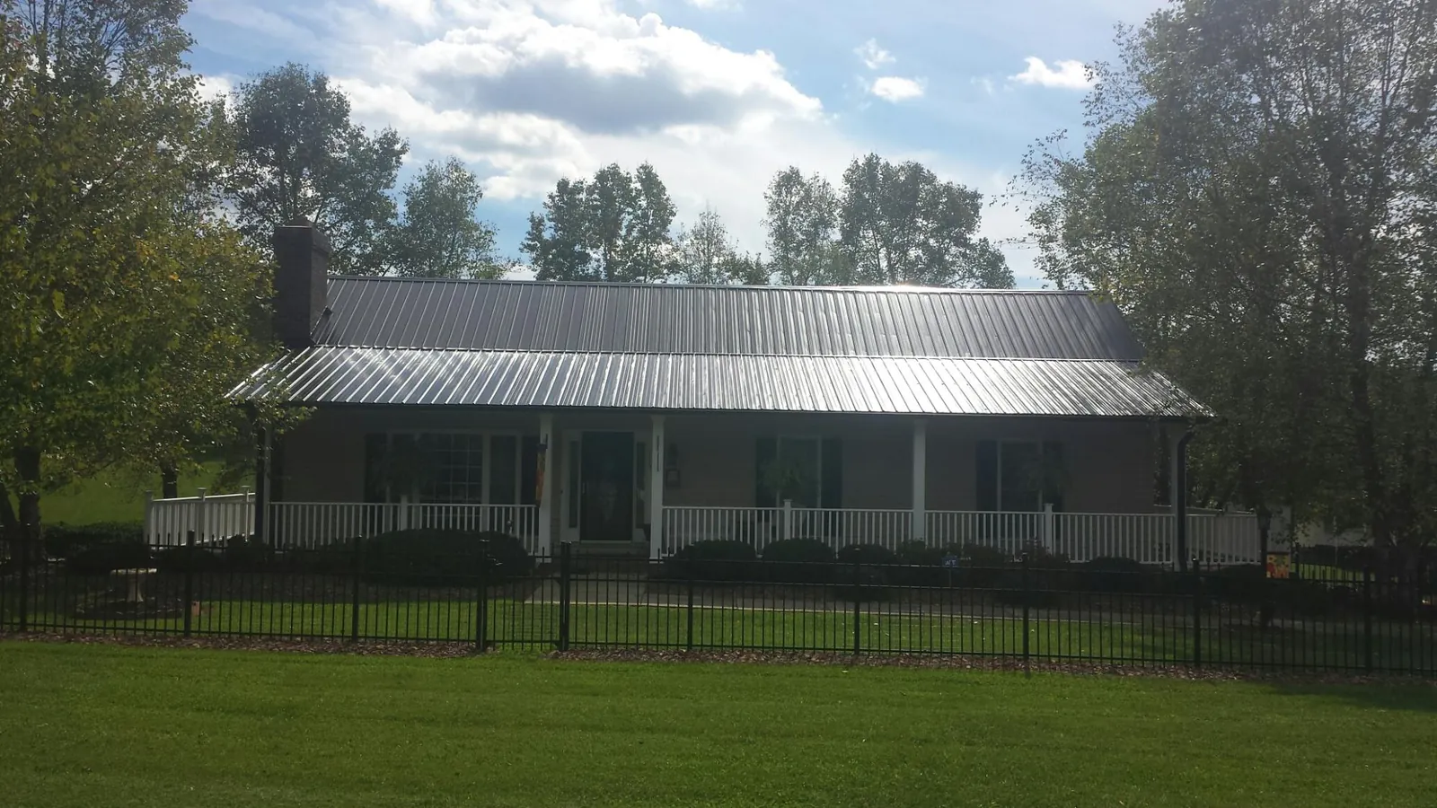 Gray metal roof on a brick ranch with a full width front porch — Gutter Guard Installation work by our crew in Codorus